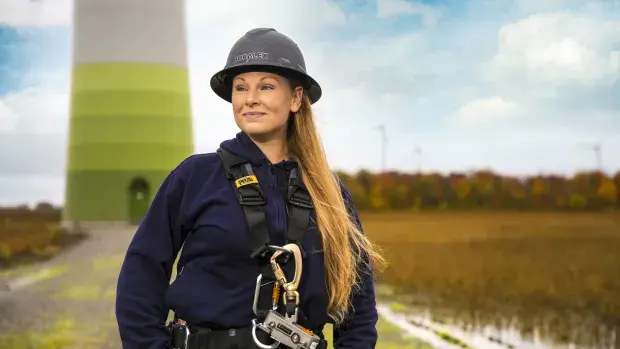 Femme technicienne face à une éolienne