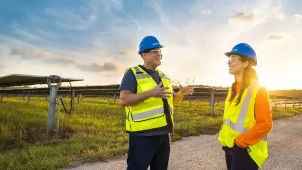Technicien solaire discutant face à un parc solaire